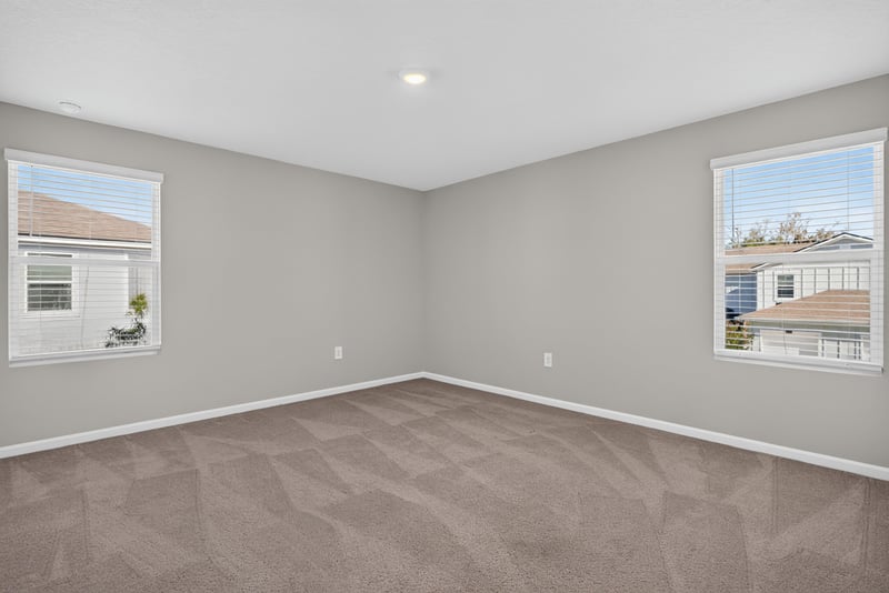 Primary bedroom with carpet and corner windows at 4024 Bay Hawk Ct, Jacksonville, FL