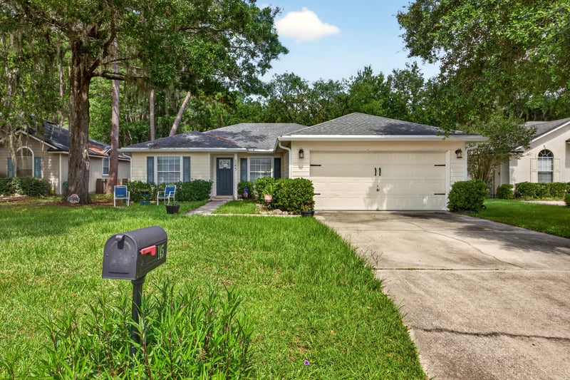 Front exterior with two-car garage and mailbox at 145 Dover Bluff Dr, Orange Park, FL