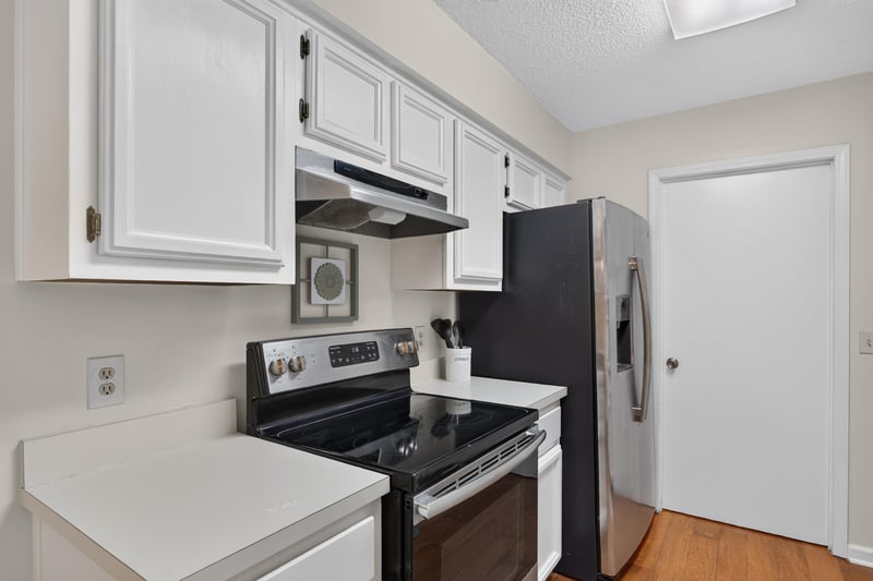 Kitchen range and refrigerator with white cabinetry at 2829 Blackberry Ave
