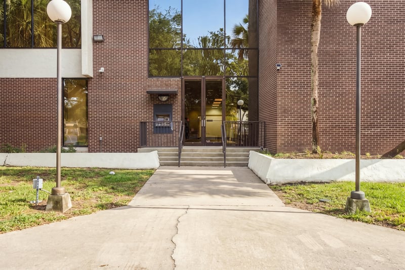 Covered entrance walkway with glass doors at 101 Scholars Wy