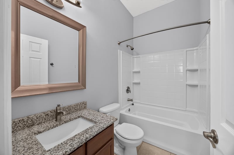 Bathroom with tub shower and granite vanity at 6217 Eclipse Cir, Jacksonville, FL 32258