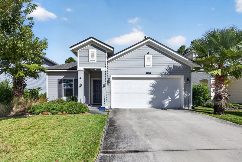 Front exterior with palm trees and driveway at 75875 Saffron Ln, Yulee, FL 32097