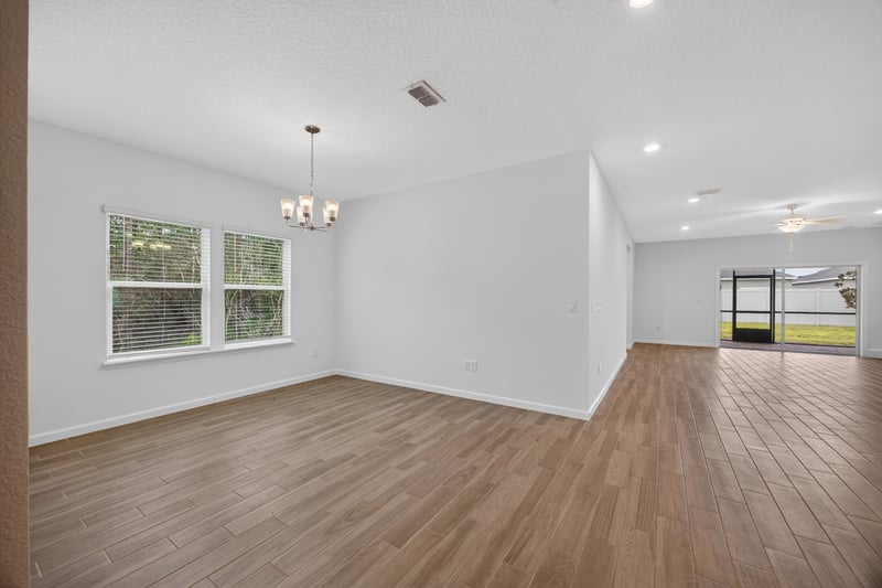 Living room with windows and wood-look flooring at 9905 Ansley Lake Dr, Jacksonville, FL