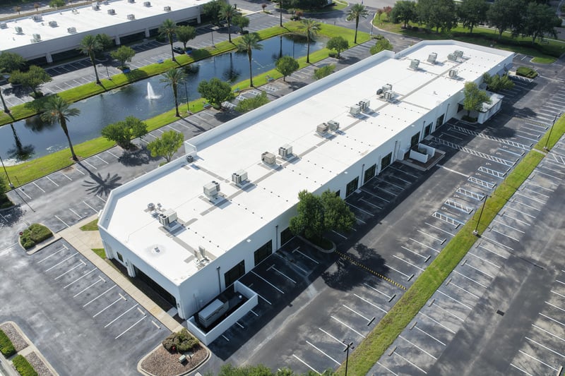 Aerial view of a building roof with pond and parking lot at 10550 Deerwood Park Blvd, Jacksonville, FL 32256