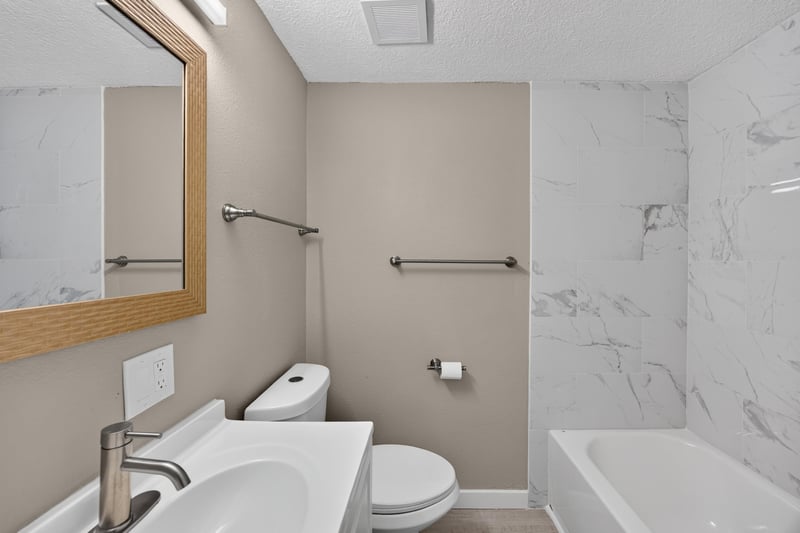 Bathroom with marble-tile tub-shower and vanity at 184 Draco St, Orange Park, FL 32073