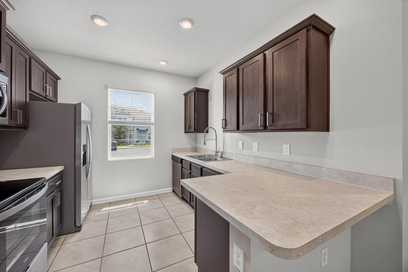 Kitchen with peninsula counter and dark cabinets at 2837 Black Buck Cir, Jacksonville, FL 32225