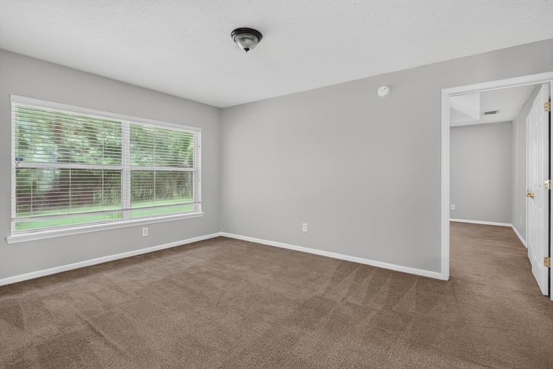 Empty carpeted room with two windows at 11669 Collins Creek Dr, Jacksonville, FL 32258