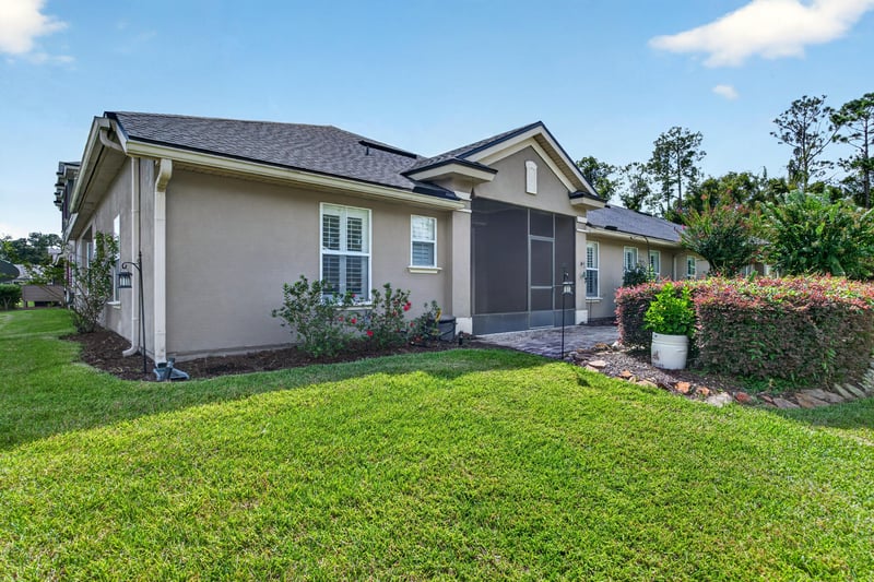 Rear exterior with screened porch and lawn at 2131 E Stone Creek Dr, Fleming Island, FL