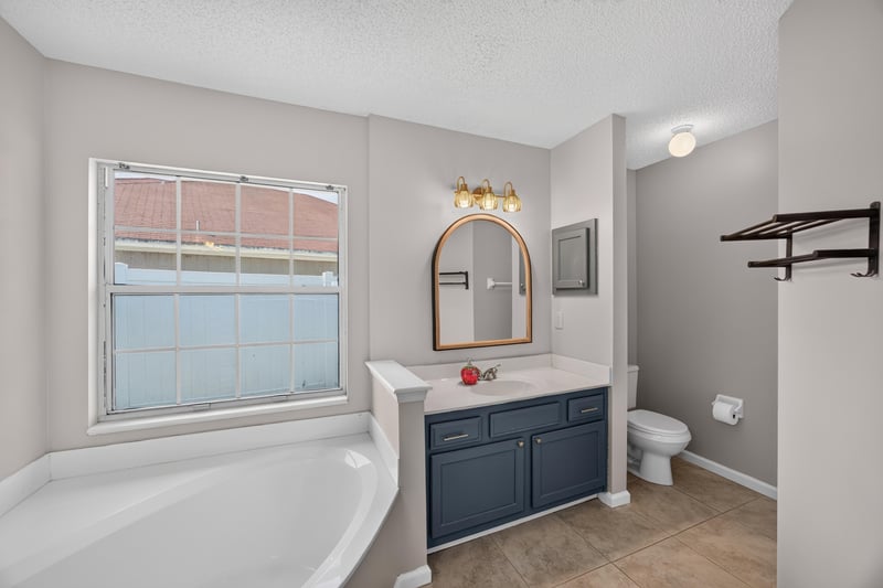Bathroom with soaking tub and mirror at 11828 Heather Grove Ln, Jacksonville, FL