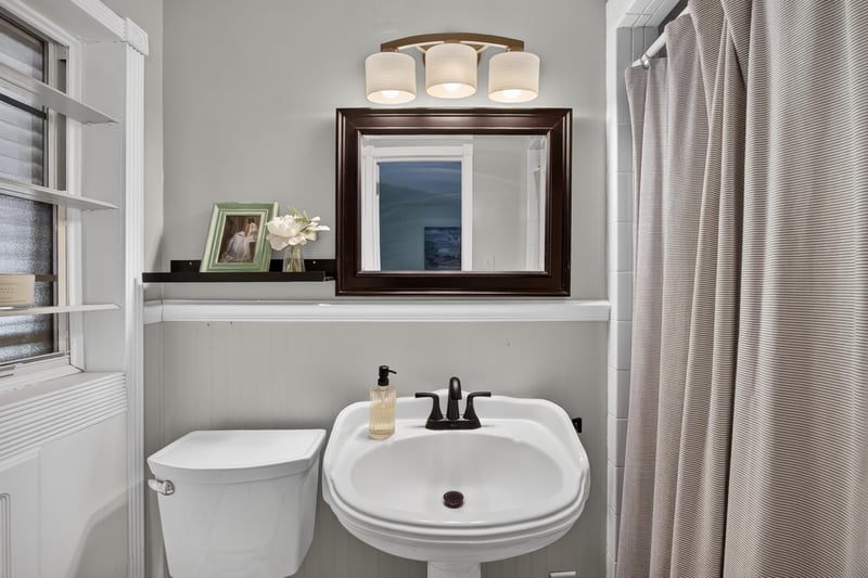 Bathroom with pedestal sink and framed mirror at 5843 Ovella Rd, Jacksonville, FL 32244