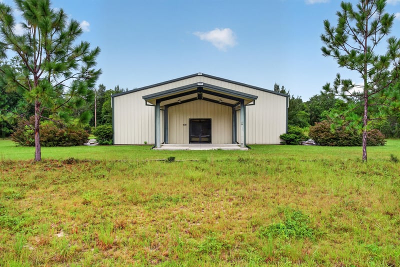 Front exterior of white metal building with gable roof and covered entry at 1038 County Rd 315, Melrose
