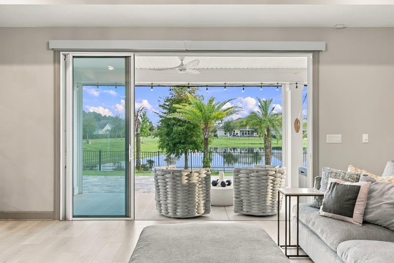 Living room sliding doors opening to the pond view at 3921 Spyglass Hill Ln