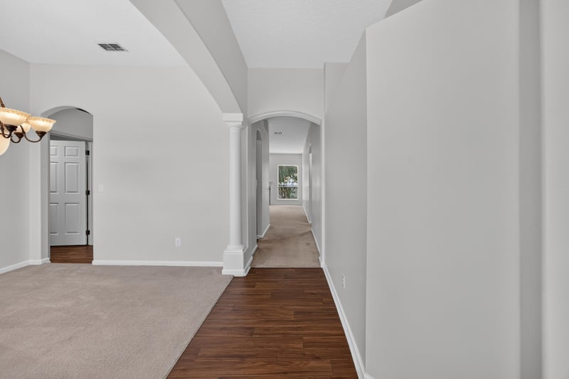 Entry hallway with arched doorway and wood flooring at 2480 Ridge Will Dr, Jacksonville, FL 32246
