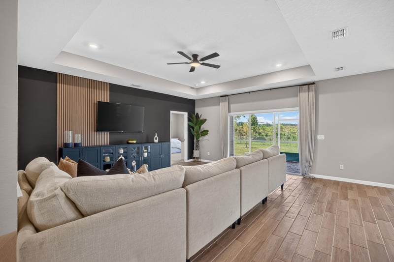 Living room with sectional sofa and ceiling fan at 9942 Lovage Ln, Jacksonville, FL 32219