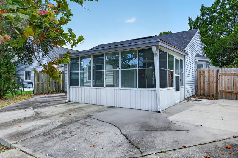 Rear exterior showing sunroom addition and concrete patio at 8047 Mactavish Way E, Jacksonville, FL 32244