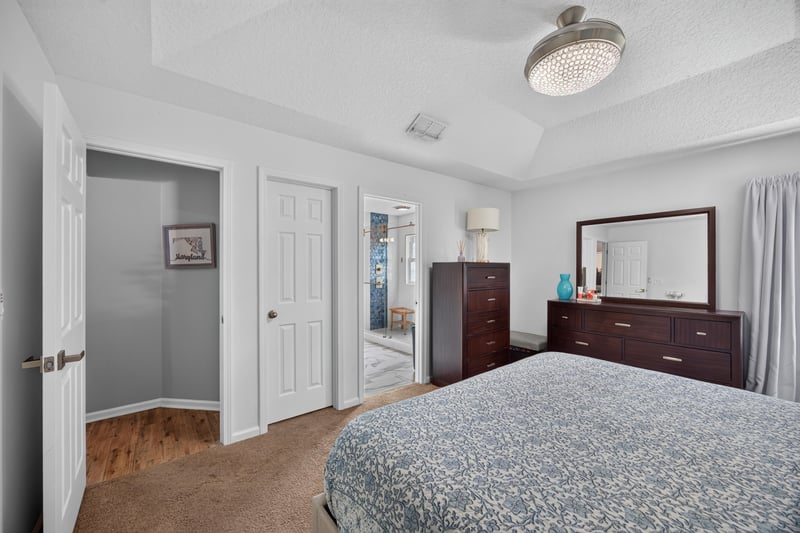 Primary bedroom with tray ceiling and dresser at 12825 Kelsey Island Dr, Jacksonville, FL 32224