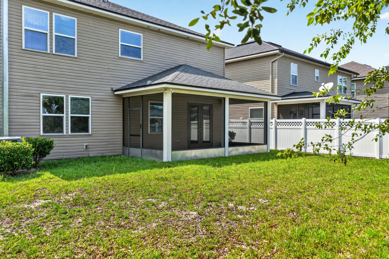Backyard with patio and lawn, neighboring homes visible at 263 Gilmore Ln, Orange Park, FL 32065
