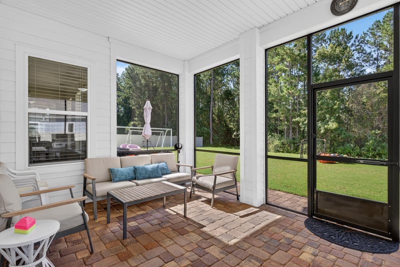 Screened porch with seating area at 22 Azura Point