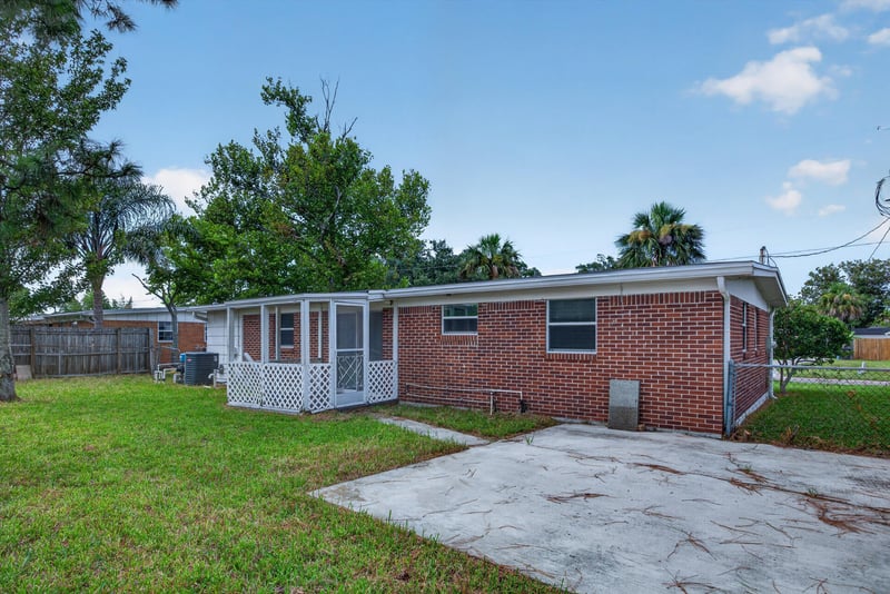 Backyard view of brick home with concrete pad at 87 Saratoga Cir S, Atlantic Beach, FL