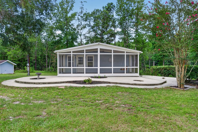 Aerial front view of screened wrap porch and curved patio at 4890 McAllister Rd, Middleburg, FL 32068