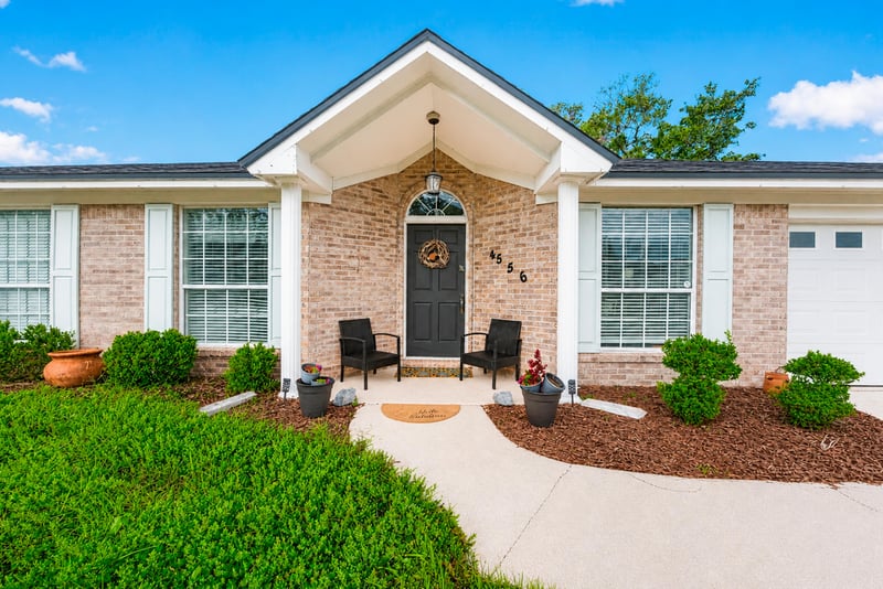 Covered front porch with seating and landscaping at 4556 Shaky Leaf Ln N, Jacksonville, FL 32224