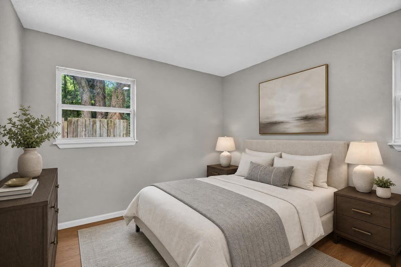 Virtually staged bedroom with bed and lamps at 7015 Miss Muffet Ln N, Jacksonville, FL 32210