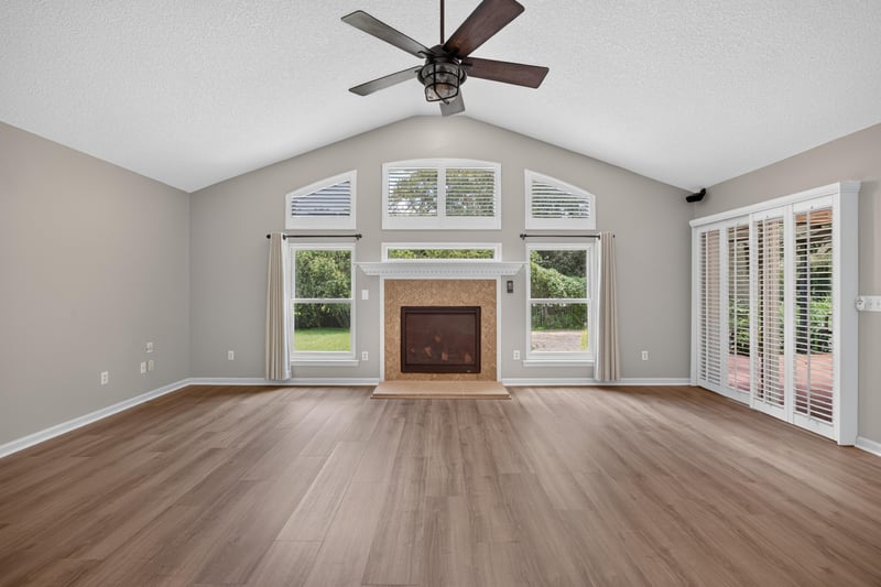 Empty living room with fireplace and wood floor at 1955 GUARDED Way, Fleming Island, FL 32003