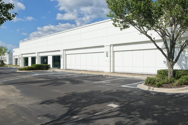 Long building facade with trees along the walkway at 10550 Deerwood Park Blvd, Jacksonville, FL 32256