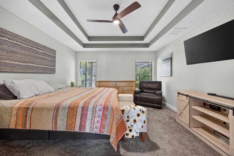 Bedroom with tray ceiling and seating area at 2125 Blue Heron Cove Dr, Orange Park, FL 32003