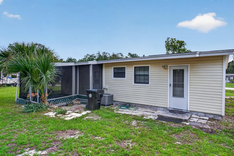 Rear exterior with screened porch and palm trees at 255 Woodside Dr, Orange Park, FL 32073