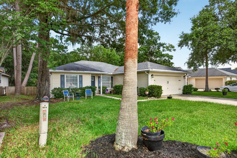 Front exterior framed by a large tree at 145 Dover Bluff Dr, Orange Park, FL