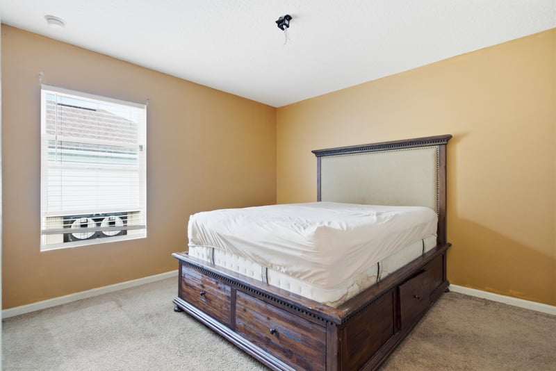 Bedroom with wood bed frame and carpet at 7392 Timber Falls Ct