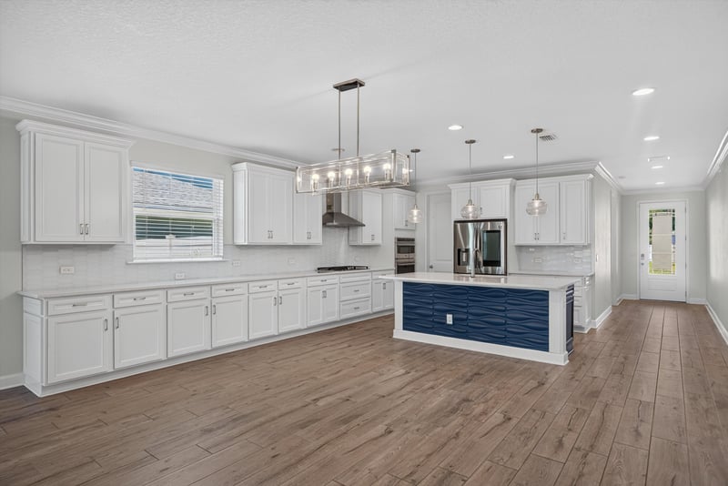 Kitchen with navy island and white cabinets at 855 Flach Dr, St. Johns, FL