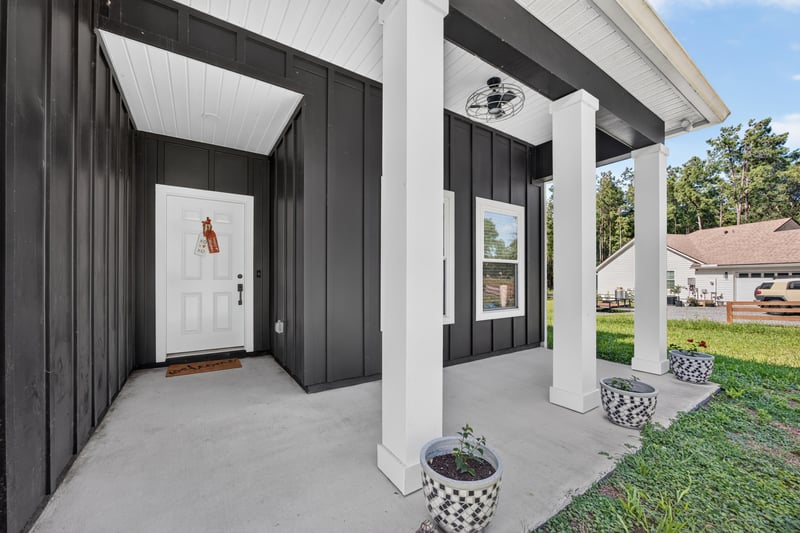 Covered front entry with dark door and columns at 2817 Camel Cir, Middleburg, FL