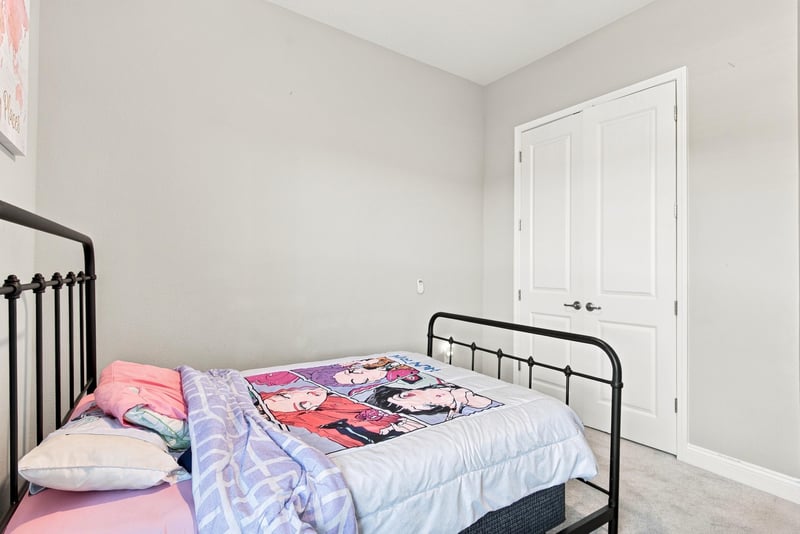 Bedroom with metal bed frame and natural light at 27 Holly Rdg Wy, St. Augustine, FL