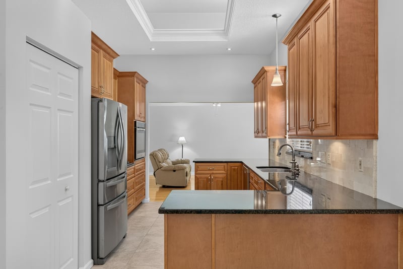 Kitchen island with stainless refrigerator at 12810 Swamp Owl Ln