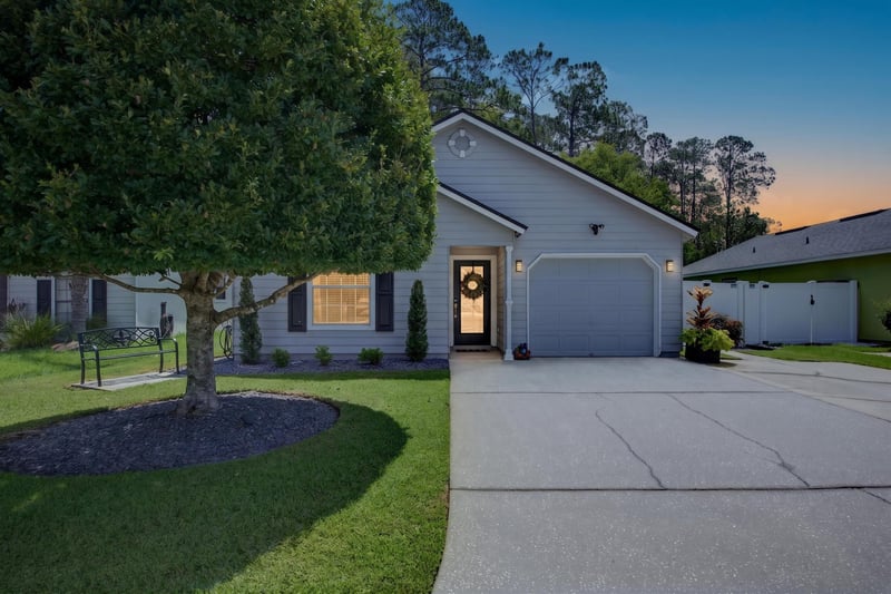 Front exterior at day-to-dusk with porch light on at 3067 Wavering Ln, Middleburg, FL 32068