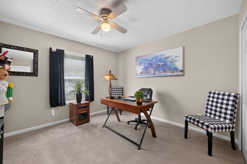 Home office with wood desk and checkered chairs at 3067 Wavering Ln, Middleburg, FL 32068