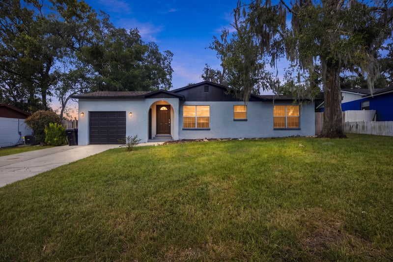 Front exterior with arched entry and oak trees at 417 Capricorn Ln, Orange Park, FL 32073