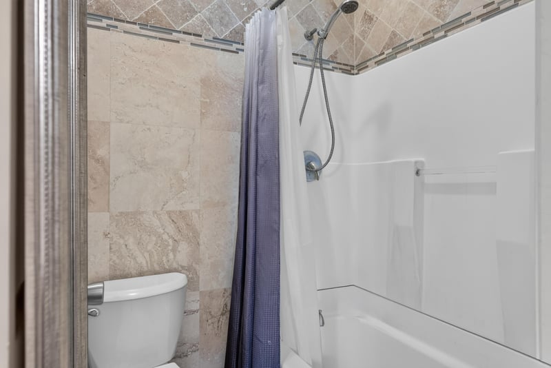 Bathroom shower with marble-look tile at 13020 Medford Ln, Jacksonville, FL 32225
