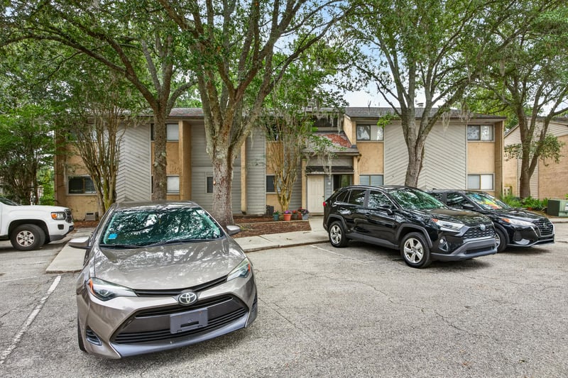 Front exterior with parking area and trees at 3801 Crown Point Rd unit 2061, Jacksonville, FL 32257