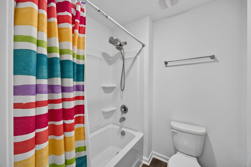 Bathroom with striped shower curtain and tub at 65255 Frst Glen Ln, Yulee, FL 32097