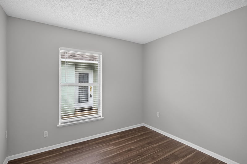 Bedroom with wood-look flooring and window at 7329 Lawn Tennis Ln, Jacksonville, FL