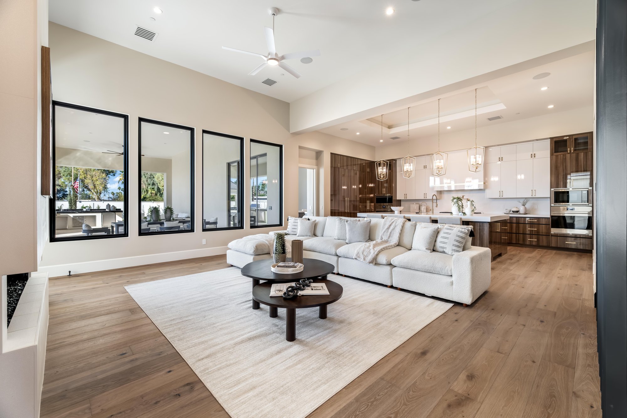 Living room with a white sectional and a wall of black-framed windows