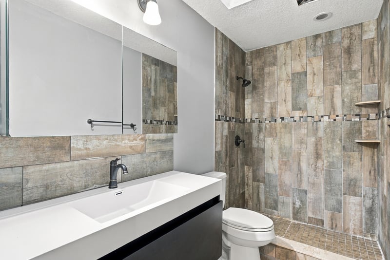Bathroom with tiled walk-in shower and dark vanity at 2915 Trenton Ct, Orange Park, FL