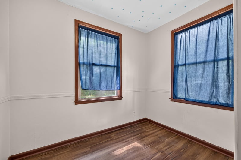 Empty bedroom with two windows and blue curtains at 2132 Allandale Cir W, Jacksonville, FL