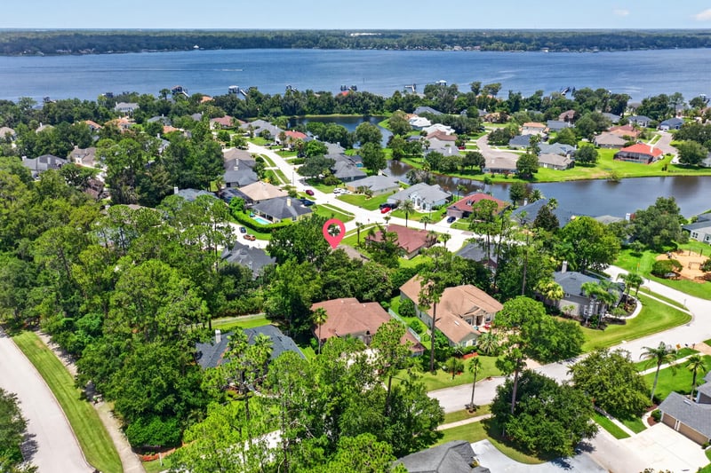Aerial day-to-dusk view of neighborhood and lake in Fleming Island, FL