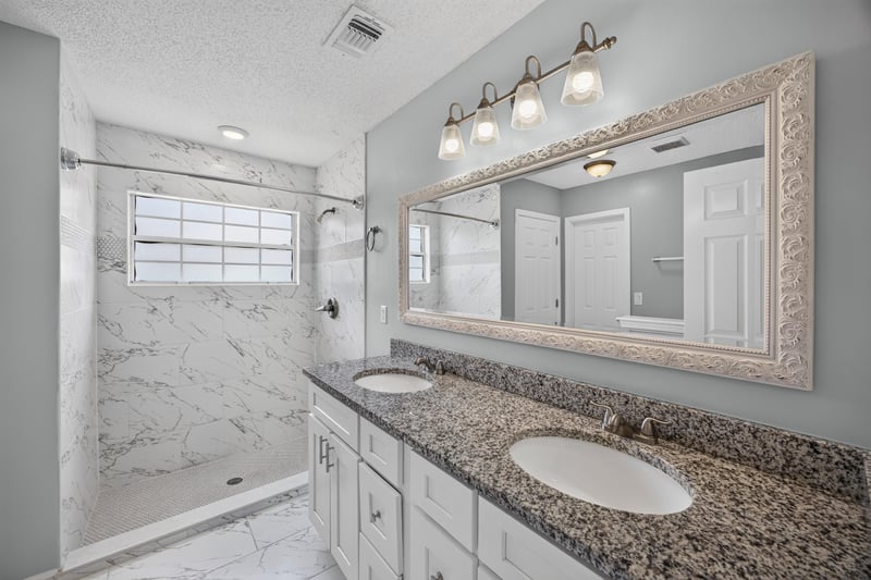 Primary bathroom with dual sink vanity and framed mirror at 490 Hillside Dr, Orange Park, FL 32073