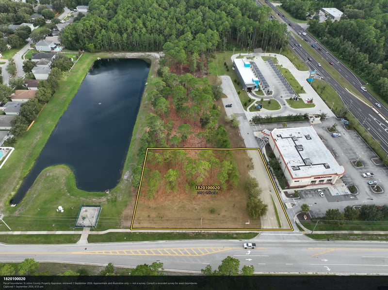 Aerial view of the pond and tree canopy bordering the parcel at 4900 US-1, St. Augustine, FL 32086