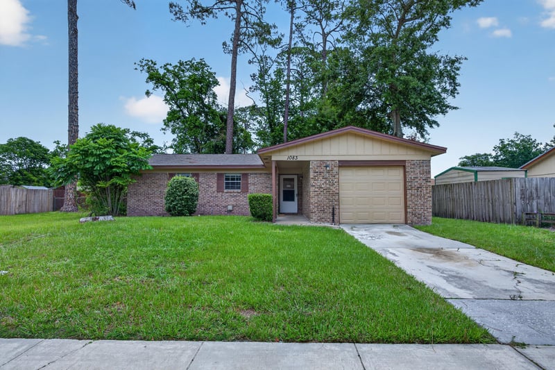 Front view of the home from across the street with mature trees at 1083 Stokes St, Jacksonville, FL